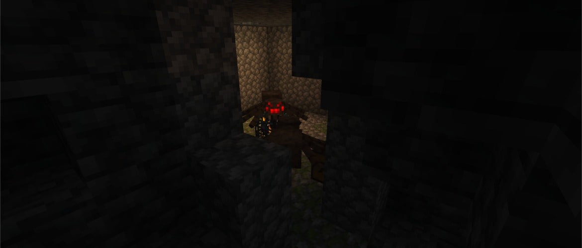 A Minecraft screenshot of a spider standing in a darkly lit environment.